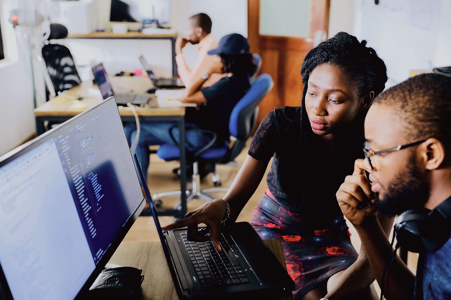 Two developers reviewing code together in front of a monitor